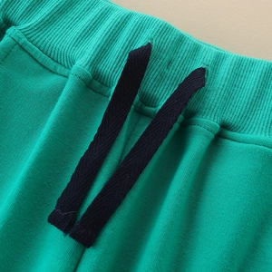 Bright green boys' cotton joggers featuring an elastic ribbed waist and woven drawstrings
