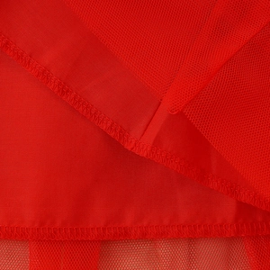 Detail of red tulle girl dress showing layered fine mesh fabric and stitching