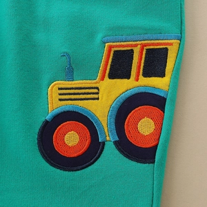 Green boys joggers featuring a high-quality embroidered cartoon tractor on soft knit fabric