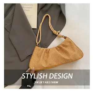 Detail show of a yellow pleated straw handbag with a woven rope handle on white background