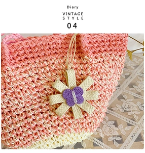 Close-up of a pink gradient woven straw bag with a purple butterfly star pendant charm