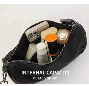 Détail montrant la capacité de stockage interne du sac polochon en nylon noir avec objets