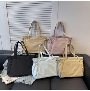 Détail de cabas en nylon multicolores avec cordon de serrage latéral en cinq nuances