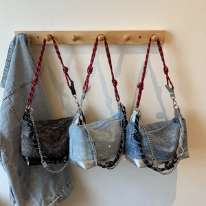 Detail of woven fabric shoulder bags with dual-color braided rope and silver chain accents