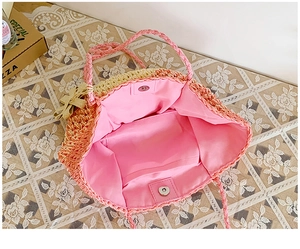 Detail of gradient straw handbag with pink fabric lining and magnetic metal snap closure
