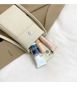 Detail view of cream lychee leather mini crossbody bag showing spacious interior space