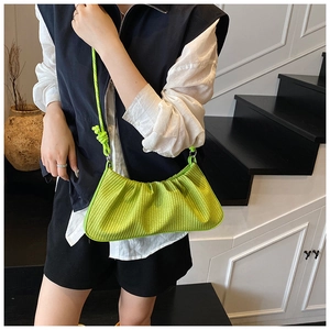 Detail view of neon green pleated bag with woven texture and matching rope shoulder strap