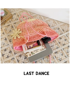 Detail of a pink gradient straw bag showing its large interior capacity and flower decor