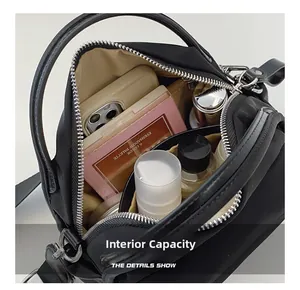 Detail view of black nylon shoulder bag showing interior compartments and large capacity