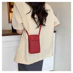 Close-up of red lychee texture leather mini crossbody phone bag on female model