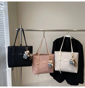 Drei minimalistische Tragetaschen in Schwarz, Rosa und Cremeweiß mit süßen Bärenanhängern
