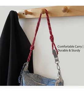 Detail of blue denim shoulder bag with red-white braided rope strap and metal hook