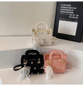 Detailed shot of three stylish lady handbags with daisy embroidery and pearl bow charms