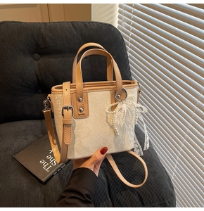 Detail der Bucket-Bag mit Schlangenprägung, Perlen-Spitzen-Anhänger und braunem Besatz