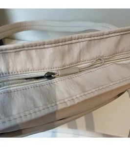 Détail de la fermeture éclair en métal et de la tirette en tissu sur le sac fourre-tout beige