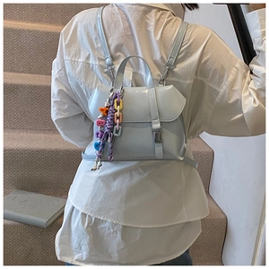Detail of light blue mini backpack with colorful acrylic letters and woven knot decor