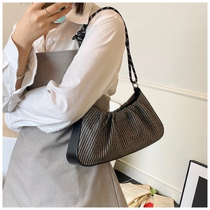Detail of woven texture and pleated design on black and white shoulder bag