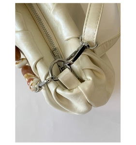 Macro view of cream pleated handbag with silver zipper and resin bead chain detail