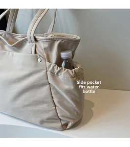 Détail de la poche latérale pour bouteille d'eau sur le grand sac fourre-tout beige