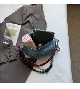 Detail of denim shoulder bag interior showing large capacity for tablet and umbrella