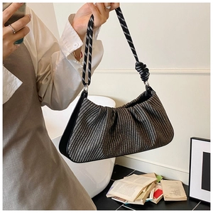 Detail of woven hobo bag showing black and white texture with chunky knotted rope handle