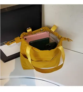 Detail of spacious yellow drawstring tote bag holding multiple tablets and smartphones