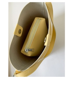 Top-down view of lemon yellow lychee grain leather bucket bag with magnetic closure