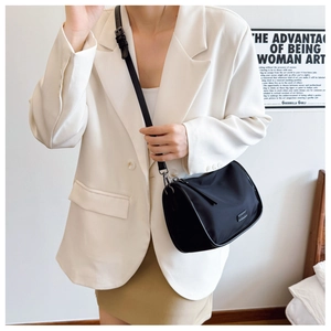 Détail d'un sac polochon noir chic en toile avec bandoulière réglable sur un modèle