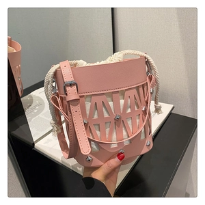 Close-up of pink hollow bucket bag with inner canvas pouch and silver metal studs