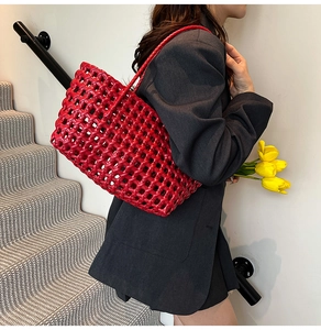 Detail of red hollow woven tote bag showing leather lattice craftsmanship and texture