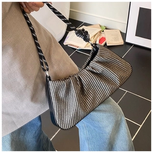 Close-up of ruched hobo bag with woven geometric pattern and thick rope shoulder strap