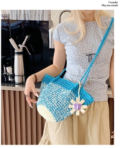 Sky blue and beige gradient woven shoulder bag with a white daisy charm decoration