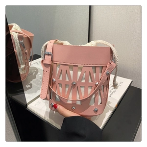 Detail of pink hollow bucket bag with silver studs and white drawstring inner pouch