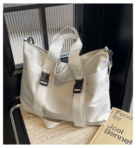 Close-up of white functional tote bag with buckle details and nylon texture