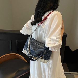 Blue denim tote bag detail featuring tricolor rope strap and metallic silver base design
