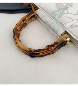 Detailed macro view of the natural bamboo handle with elegant gold metal connectors