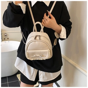 Detailansicht des cremeweißen Mini-Rucksacks mit Spitzenbesatz und Schleife aus PU-Leder