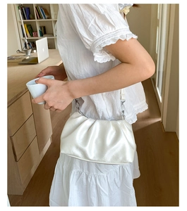 White ruched cloud bag with silver chain and leather strap worn by model in office setting