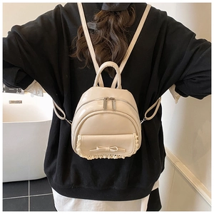 Nahaufnahme des weißen Mini-Lederrucksacks mit Spitzenkanten und süßer Schleife