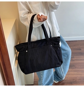 Détail de la poche latérale élastique et rivet sur le cabas en toile noire