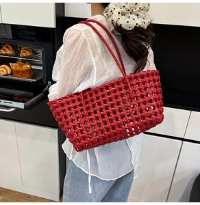 Detail of red hollow mesh woven tote bag on shoulder for summer beach vacations