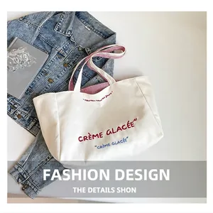 Détail du cabas en toile avec broderie française rouge et bleue et anses à rayures