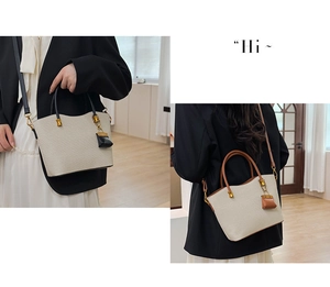Detail of beige textured tote bag with wave-edge design and decorative mini pouch charm