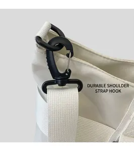 Detail of durable black swivel hook and nylon webbing on a large canvas tote bag