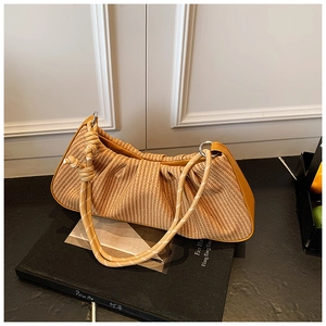 Detail of light brown woven baguette bag with yellow leather trim and thick rope handle