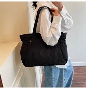 Vue lifestyle d'un grand sac cabas en toile noire avec détails de cordon sur le mannequin
