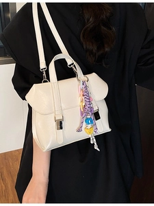Minimalist beige PU leather bucket bag with silver buckle and colorful beaded charm