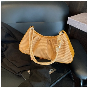 Detailed view of yellow pleated woven handbag texture with braided rope handle
