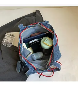 Top view of spacious denim tote interior with colorful ropes and daily essentials