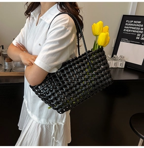 Detail of the hollowed-out black woven tote bag texture with elegant tulip accessory